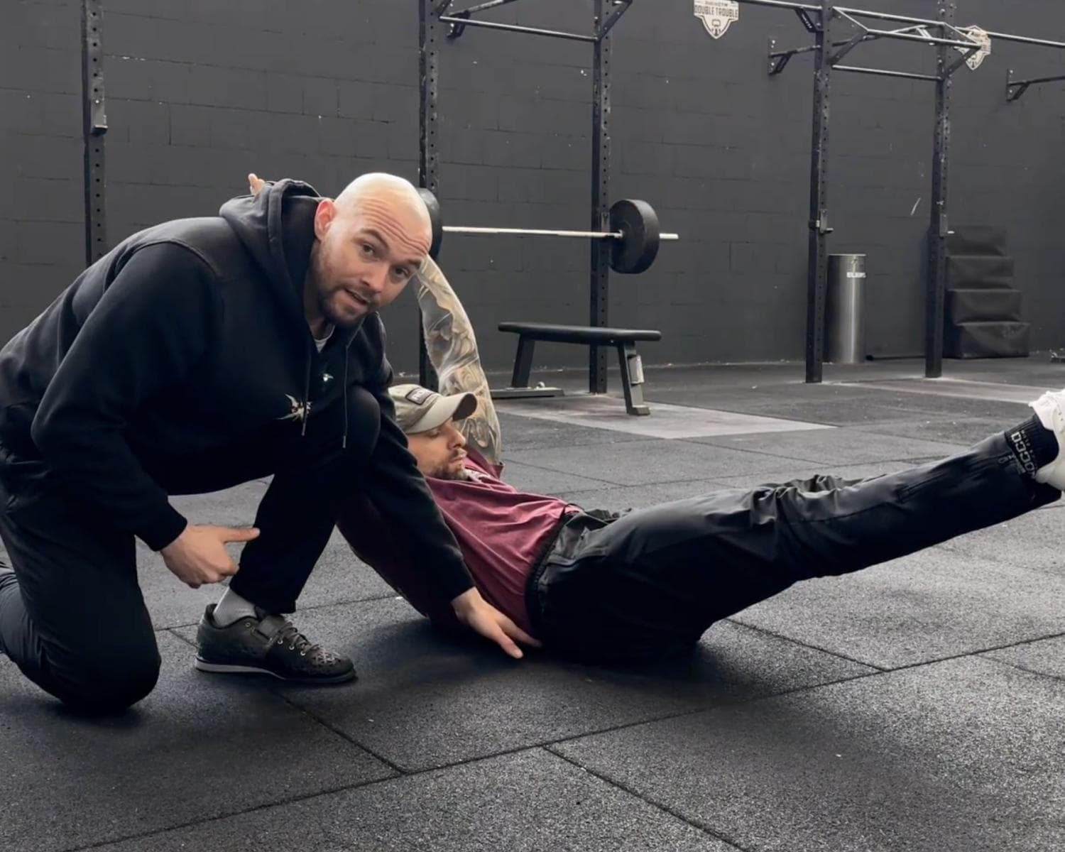 Trainer korrigiert eine Übung am Boden